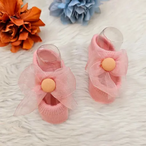 Baby Socks Or Booties With A Decorative Bow And Button Detail