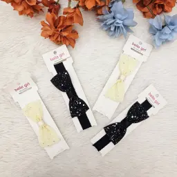 Black Cream Bow With A Speckled Or Glittery Pattern, Attached To An Elastic Headband